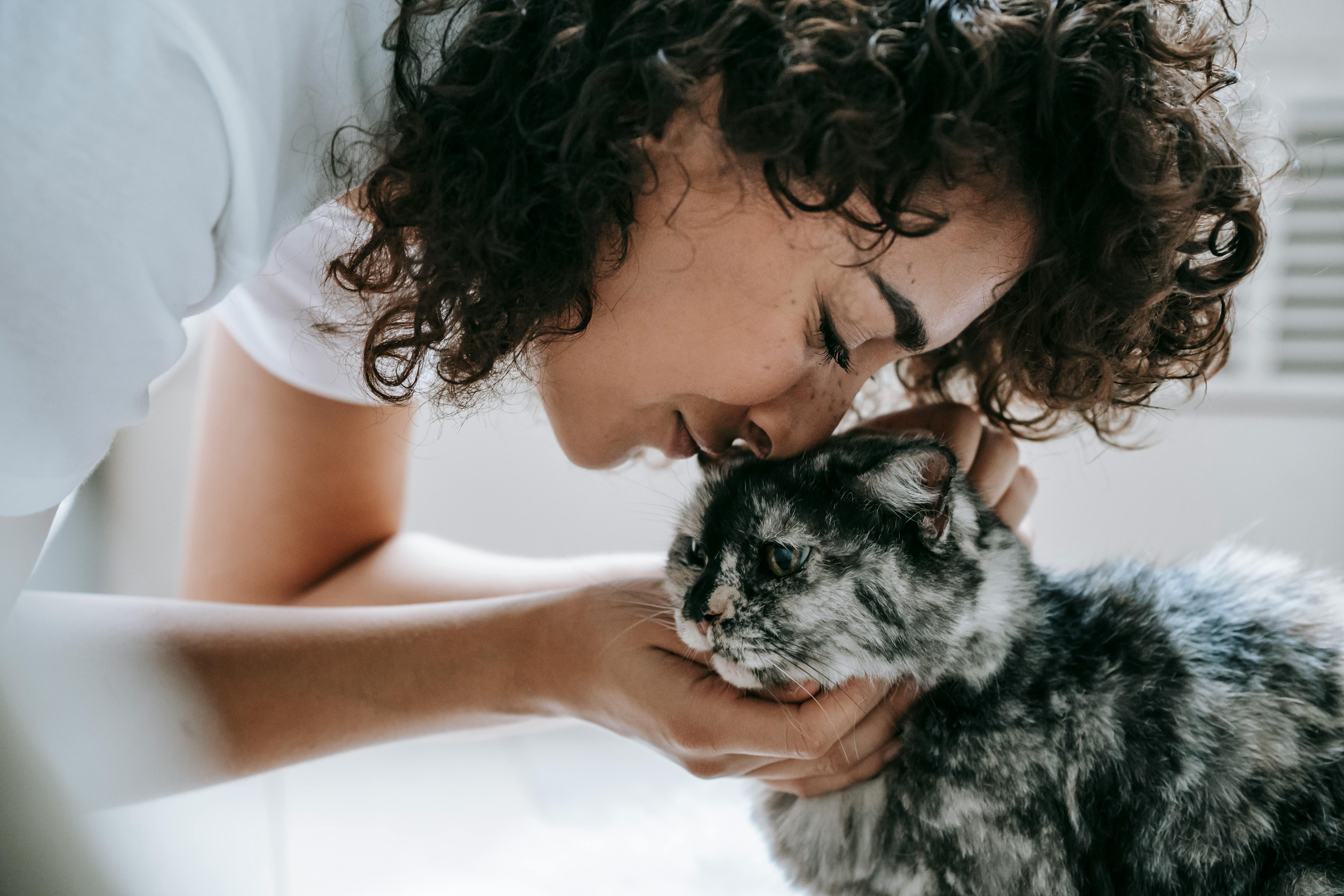 Woman touching cat with nose. Photo by Sam Lion